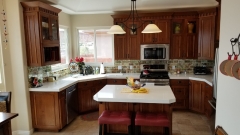 Grand Contrasting White Countertops against Hazel Cabinets